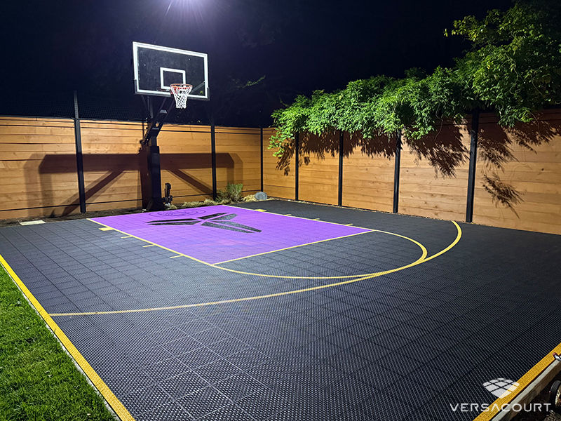 Black and purple VersaCourt half court lit at night